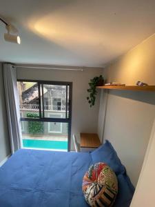 1 dormitorio con cama azul y vistas a la piscina en SUH Lapa 05 Pool Flat, en Río de Janeiro