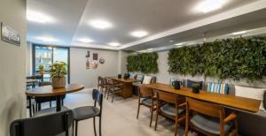 Un restaurante con mesas y sillas y plantas en la pared. en SUH Lapa 05 Pool Flat, en Río de Janeiro