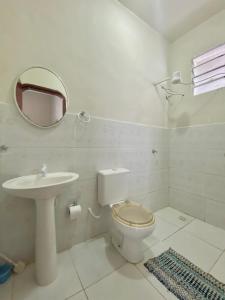 a bathroom with a toilet and a sink and a mirror at Apartamento Arena da Amazônia in Manaus