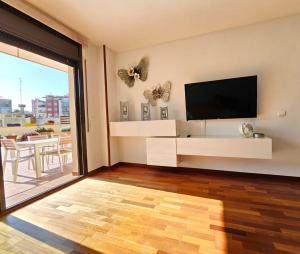 una sala de estar con TV y mariposas en la pared en Apartamento Vilallonga, en Figueres