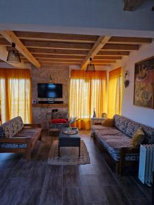ein Wohnzimmer mit Sofas und einem Flachbild-TV in der Unterkunft Beogradjanka mala in Zvornik