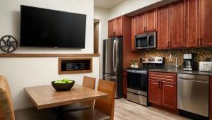 a kitchen with a table and a television on the wall at Fresh SNOW! Exquisite Upscale Oasis · Ski Resort in Breckenridge