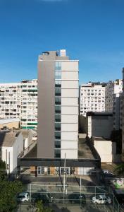 里約熱內盧的住宿－ibis budget RJ Praia de Botafogo，一座高大的白色建筑,在城市里装有汽车