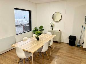 a dining room with a wooden table and white chairs at Large Townhouse 5 Beds with Two Parking Spaces - Manchester City Centre in Manchester