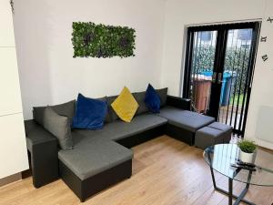 ein Wohnzimmer mit einem Sofa und einem Glastisch in der Unterkunft Large Townhouse 5 Beds with Two Parking Spaces - Manchester City Centre in Manchester