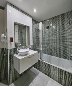 uma casa de banho com um lavatório e uma banheira em Apartamento Vilallonga em Figueres