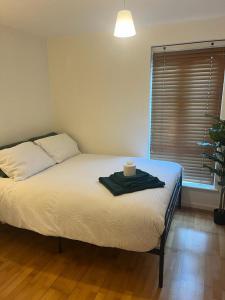 a bedroom with a bed with a towel on it at Easy Stay London - Bright and airy 2Bed Apart in London