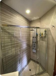 eine Dusche mit einer Glastür in einem Badezimmer in der Unterkunft Room's Service Swieqi in Tal-Għoqod