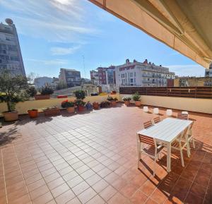 um pátio com uma mesa branca e cadeiras num telhado em Apartamento Vilallonga em Figueres