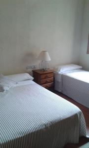 Habitación con 2 camas y mesa con lámpara. en Casa Rural en pleno paraje natural La Chirala en Enguera