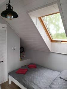 łóżko w pokoju z oknem w obiekcie Apartament pod Dębem w mieście Bobolice