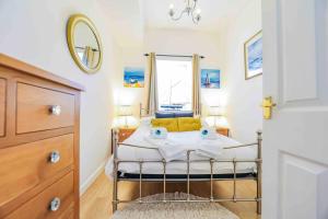 a small bedroom with a bed and a mirror at Waterside & Marina View Apartment in Torquay in Torquay