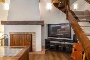 a living room with a television and a staircase at CARCAVELOS CHALLET in Carcavelos