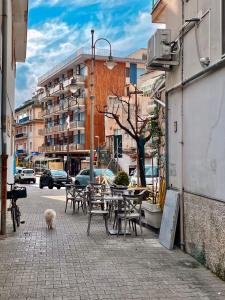 a patio with tables and chairs on a city street at Putechella's Apartments in Maiori