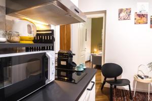 uma cozinha com um micro-ondas e uma bancada preta em Gli Appartamenti al Duomo em Catânia