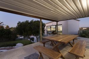 a wooden table and benches on a patio at Korhaan House in Melkbosstrand