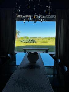 a dining room with a table and a large window at Casa de campo en Capilla del Señor in Capilla del Señor