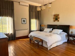 a bedroom with a large bed with white sheets at Casa de campo en Capilla del Señor in Capilla del Señor +28 photos