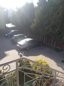 a couple of cars parked in a parking lot at City Center Apartments Mostowa 17A in Augustów