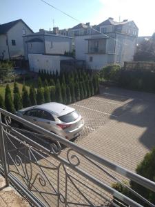 a car parked on a driveway in front of a house at City Center Apartments Mostowa 17A in Augustów