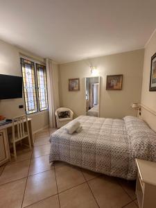 a bedroom with a bed and a desk and a television at Camere Chicca in Sanremo