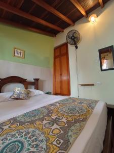 1 dormitorio con 1 cama y ventilador en la pared en ADVENTURE Hostel en San Gil