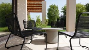 three chairs and a table on a patio at Pnoe Eco Residences in Amalias