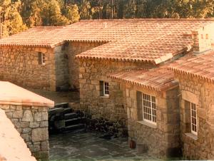 an overhead view of two stone houses with tile roofs at Casa Mata da Ribeira in Barcelos