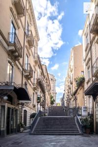 um grupo de escadas numa rua com edifícios em Gli Appartamenti al Duomo em Catânia