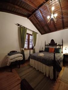 a bedroom with a bed and a chandelier at Casario do Vale Hospedagem e Eventos in Assento