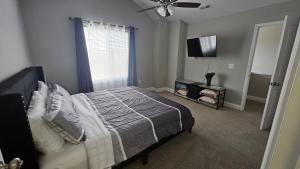 a bedroom with a bed and a flat screen tv at Spacious 3-Bedroom Modern Home Near CLT Motor Speedway in Concord