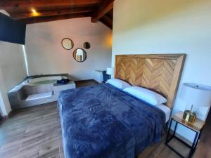 um quarto com uma cama grande e uma banheira em El Roble de los Abuelos Hotel de Montaña Colibri em Mazamitla
