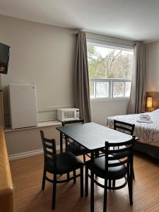 um quarto com uma mesa e cadeiras e uma cama em Auberge Morritt em Mont-Tremblant