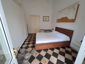 una camera con un letto e un pavimento a scacchi di Davantialmare a Livorno