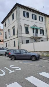 2 voitures garées sur un parking en face d'un immeuble dans l'établissement Davantialmare, à Livourne