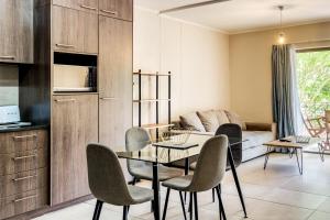eine Küche und ein Wohnzimmer mit einem Tisch und Stühlen in der Unterkunft Belina - Mayfair Premier in Kapstadt