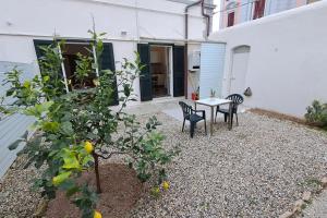 un patio avec une table et des chaises à côté d'un bâtiment dans l'établissement Davantialmare, à Livourne