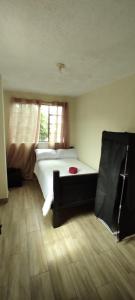 sypialnia z białym łóżkiem i oknem w obiekcie 1 Cuarto independiente individual w mieście Ambato