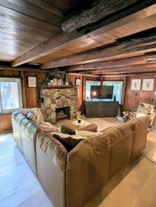 1 sofá grande en una sala de estar con chimenea de piedra. en Rustic Escape in Greenwood Lake en West Milford