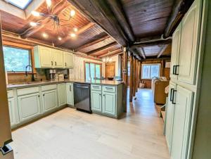a kitchen with white cabinets and a wooden ceiling at Rustic Escape in Greenwood Lake in West Milford