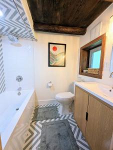 uma casa de banho com uma banheira, um WC e um lavatório. em Rustic Escape in Greenwood Lake em West Milford