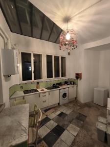 Il comprend une cuisine avec des placards blancs et un lustre. dans l'établissement Appartamenti della Valle, à Trieste