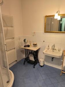 La salle de bains est pourvue d'une table, d'un lavabo et d'un miroir. dans l'établissement Appartamenti della Valle, à Trieste