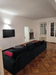Il comprend un salon doté d'un canapé noir et d'une télévision à écran plat. dans l'établissement Appartamenti della Valle, à Trieste