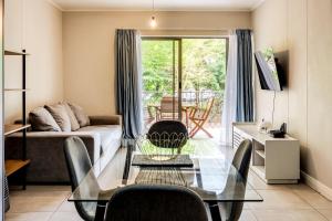 sala de estar con mesa de cristal y sofá en Belina - Mayfair Premier en Ciudad del Cabo