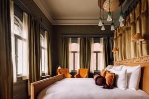 Schlafzimmer mit einem großen weißen Bett und Fenstern in der Unterkunft Villa Inkognito by Sommerro in Oslo