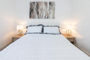 een slaapkamer met een wit bed en 2 lampen bij Free Parking Guaranteed Weekly & Monthly Stay Savings Close to City Centre in Reading