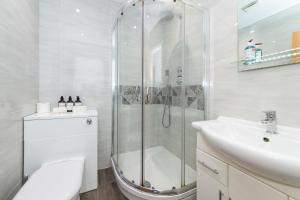 een witte badkamer met een douche en een wastafel bij Free Parking Guaranteed Weekly & Monthly Stay Savings Close to City Centre in Reading