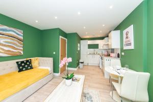 een woonkamer met groene muren en een bank bij Free Parking Guaranteed Weekly & Monthly Stay Savings Close to City Centre in Reading