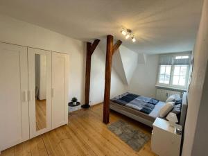 Un dormitorio con una cama con postes de madera. en Zentrale DG-Oase in Jugendstilvilla (mit Stadtblick), en Wittlich